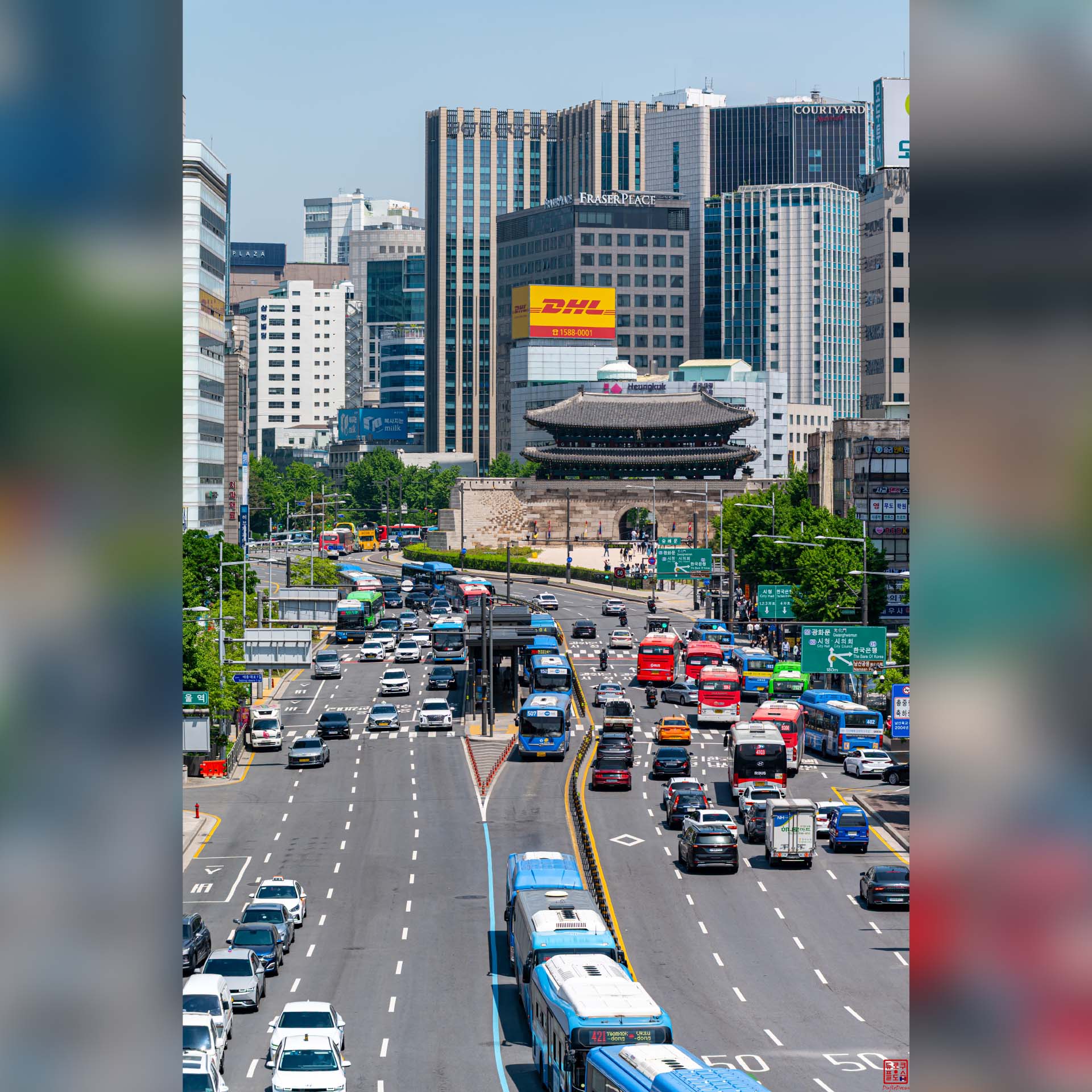Dense circulation automobile sur une grande artère bordée d'immeubles à Séoul