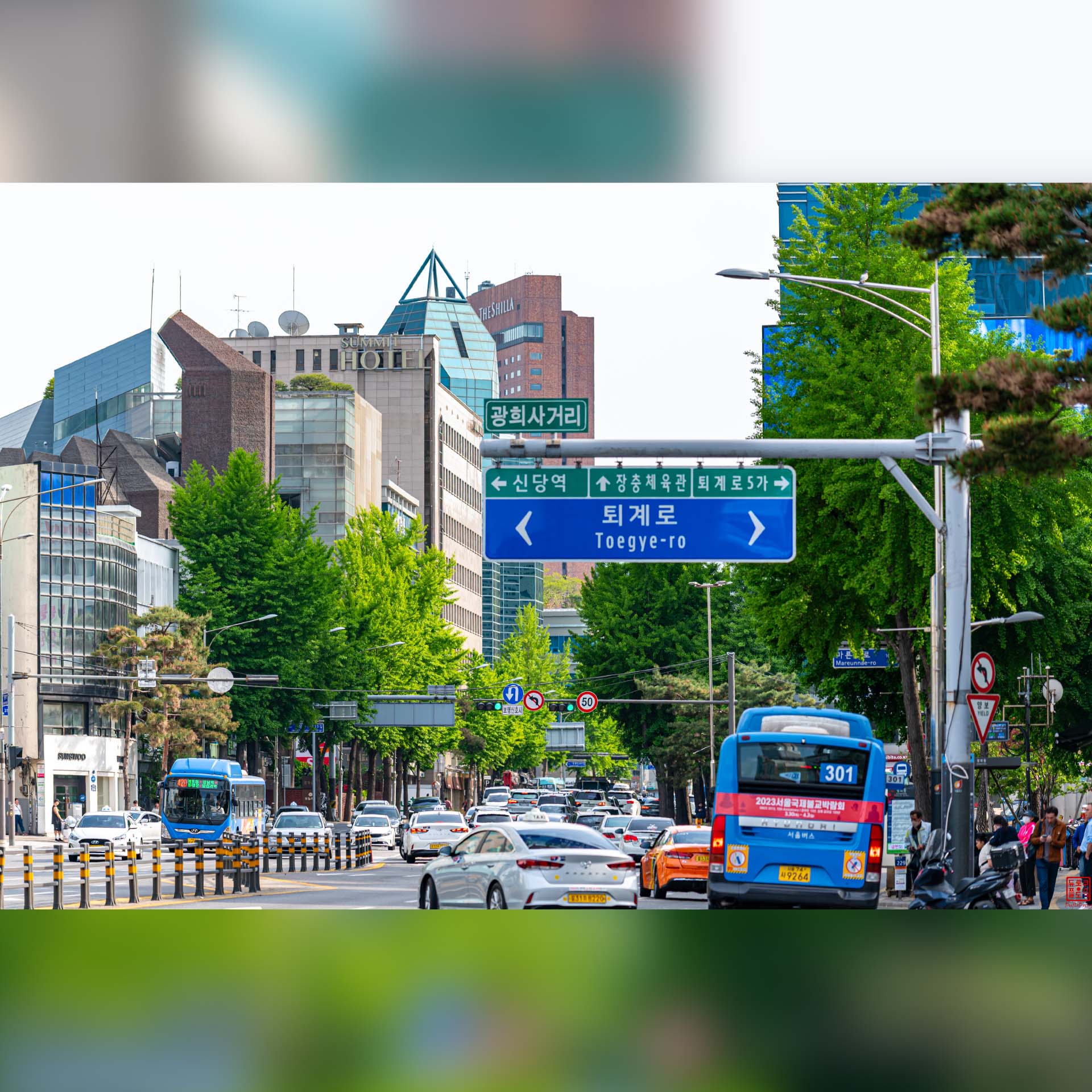 Circulation automobile et signalisation urbaine animée dans une avenue de Séoul